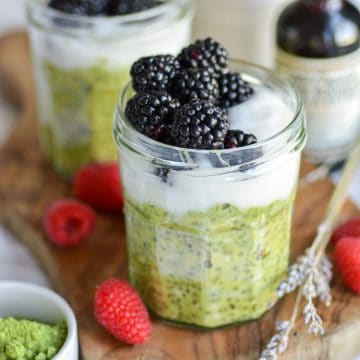 Vegan Matcha Overnight oats in a jar. The oats are topped with yogurt and berries.