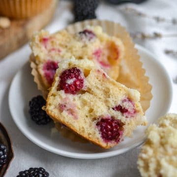 Vegan Blackberry Muffin that is broken open to show the interior on a small plate.