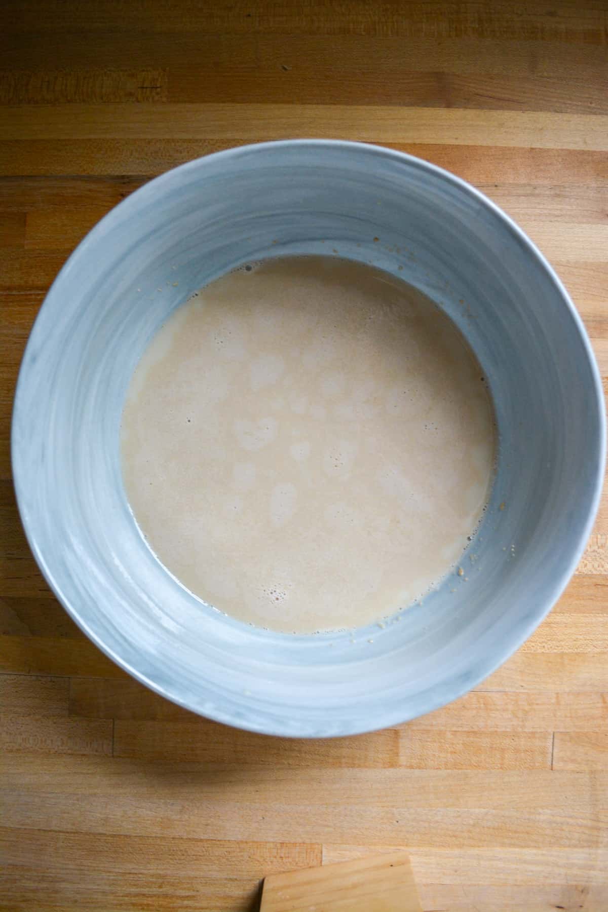 Yeast blooming in non-dairy milk in a mixing bowl.