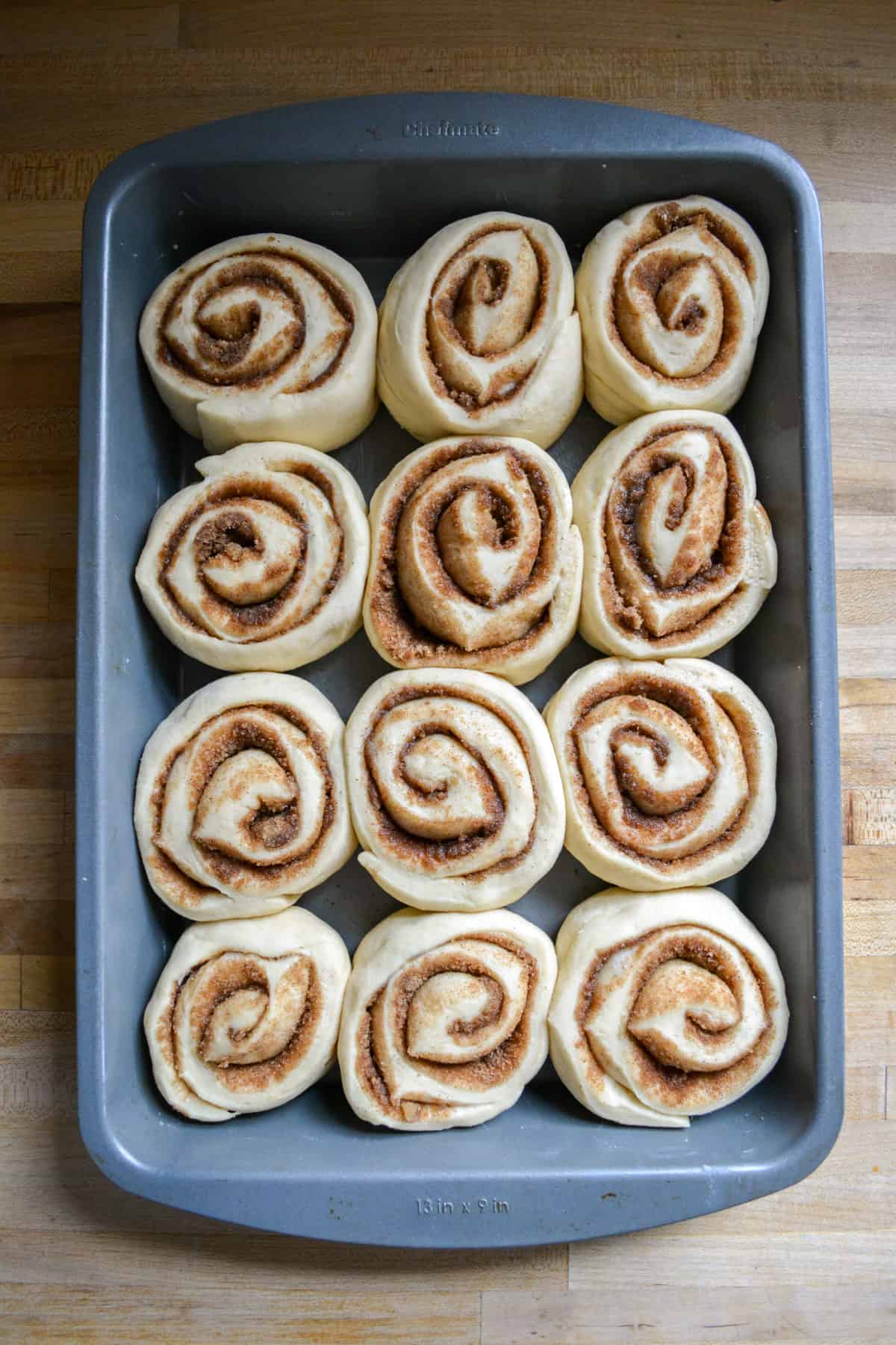 Risen cinnamon buns ready to be baked.