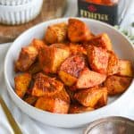 Vegan Spicy Harissa Roasted Potatoes piled into a shallow bowl.