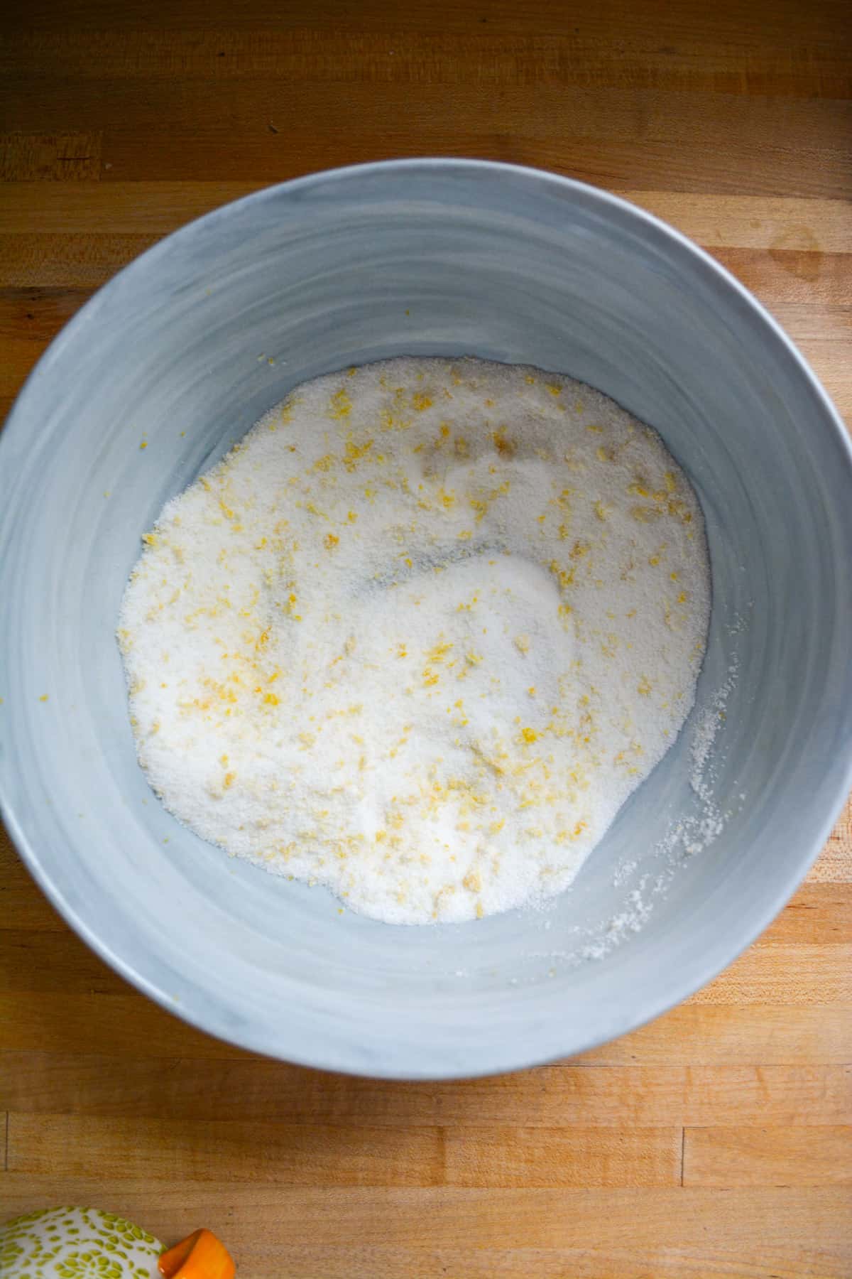 Sugar and lemon zest in a mixing bowl.