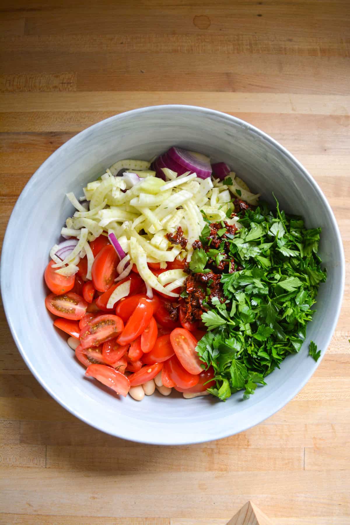 Ingredients for bean salad in a large mixing bowl.