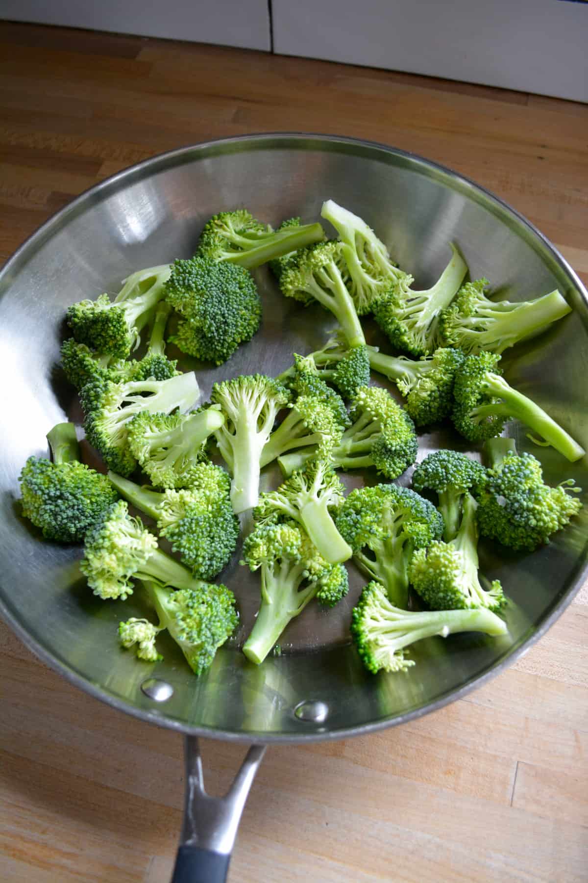 Broccoli florets in a large skillet.