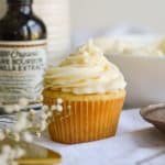 A cupcake with vegan cream cheese frosting piped on top.