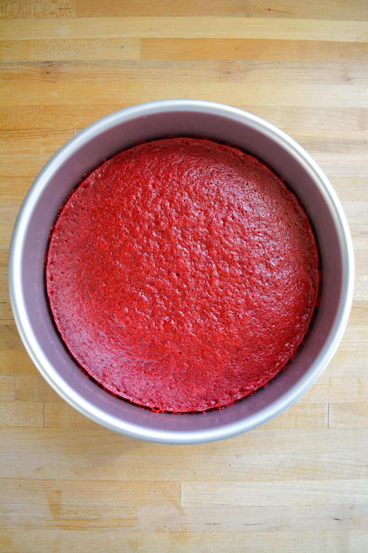 Baked cake layer in a round cake pan.