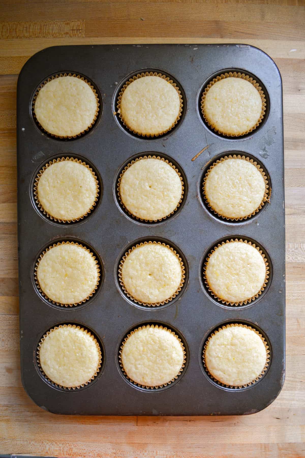 Vegan vanilla cupcakes baked in a cupcake tin.