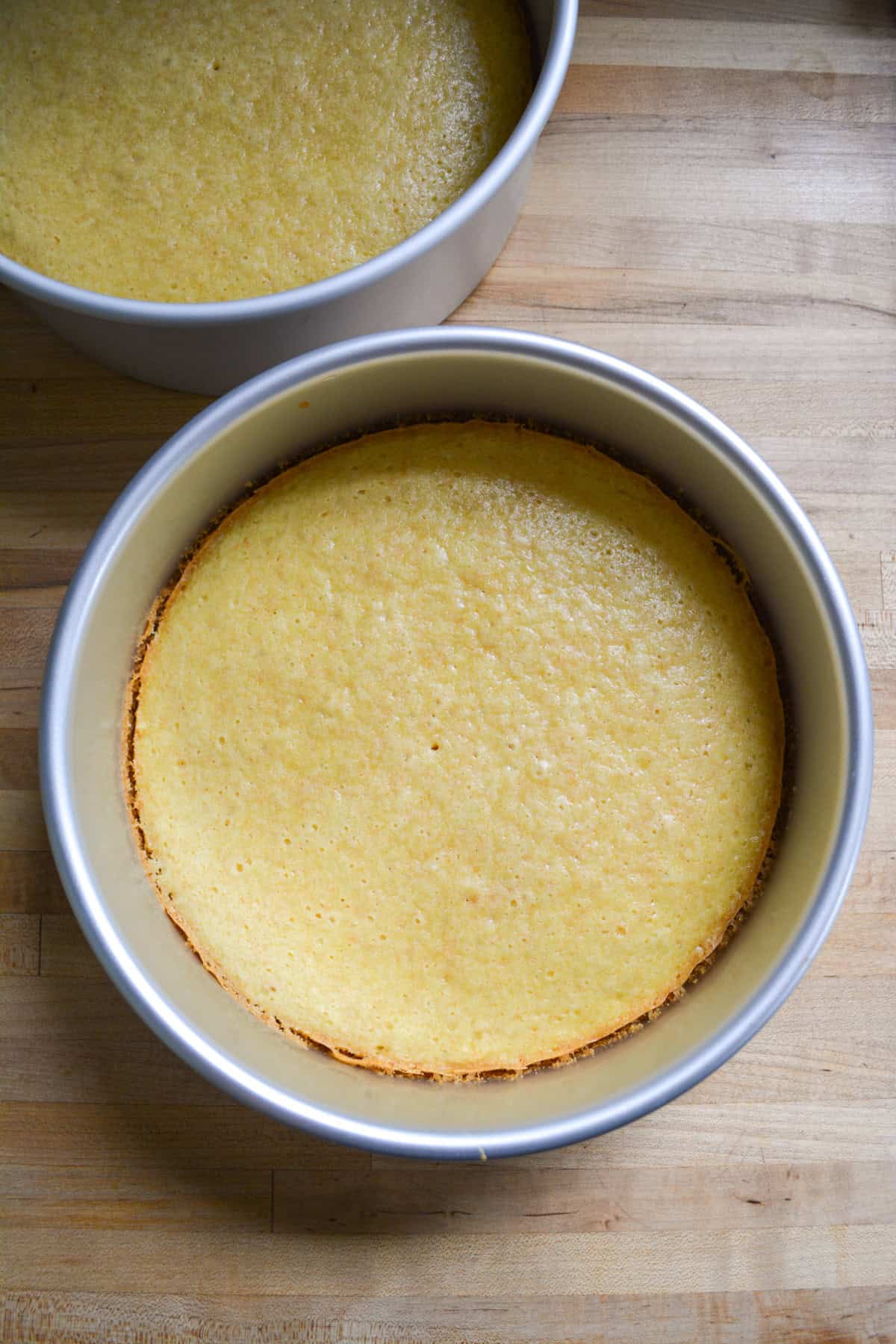 Baked vegan yellow cakes in their cake pans.