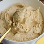 Vegan Peanut Butter Frosting in a bowl with a spoon inside the frosting,