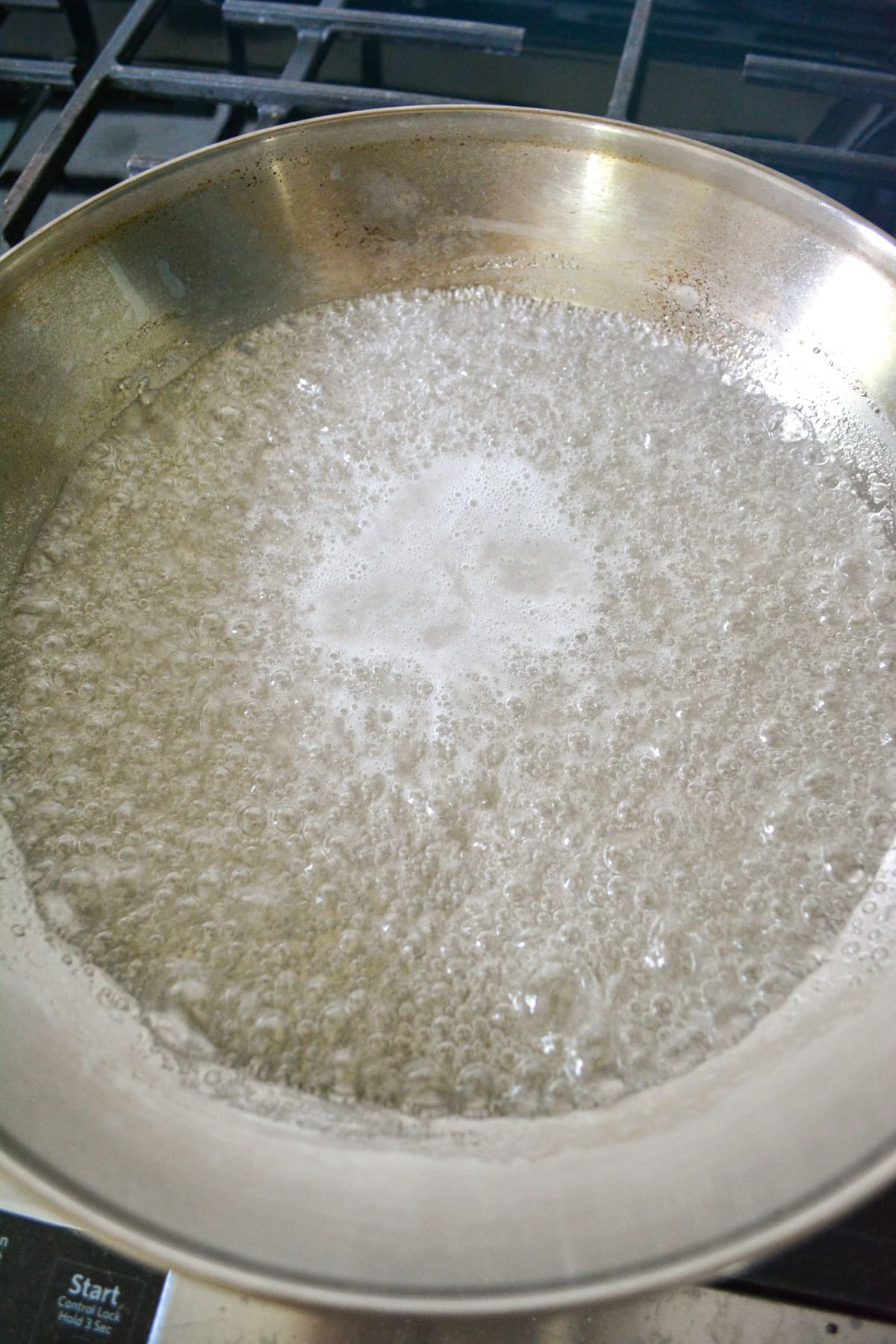 Boiling sugar syrup in a large skillet.