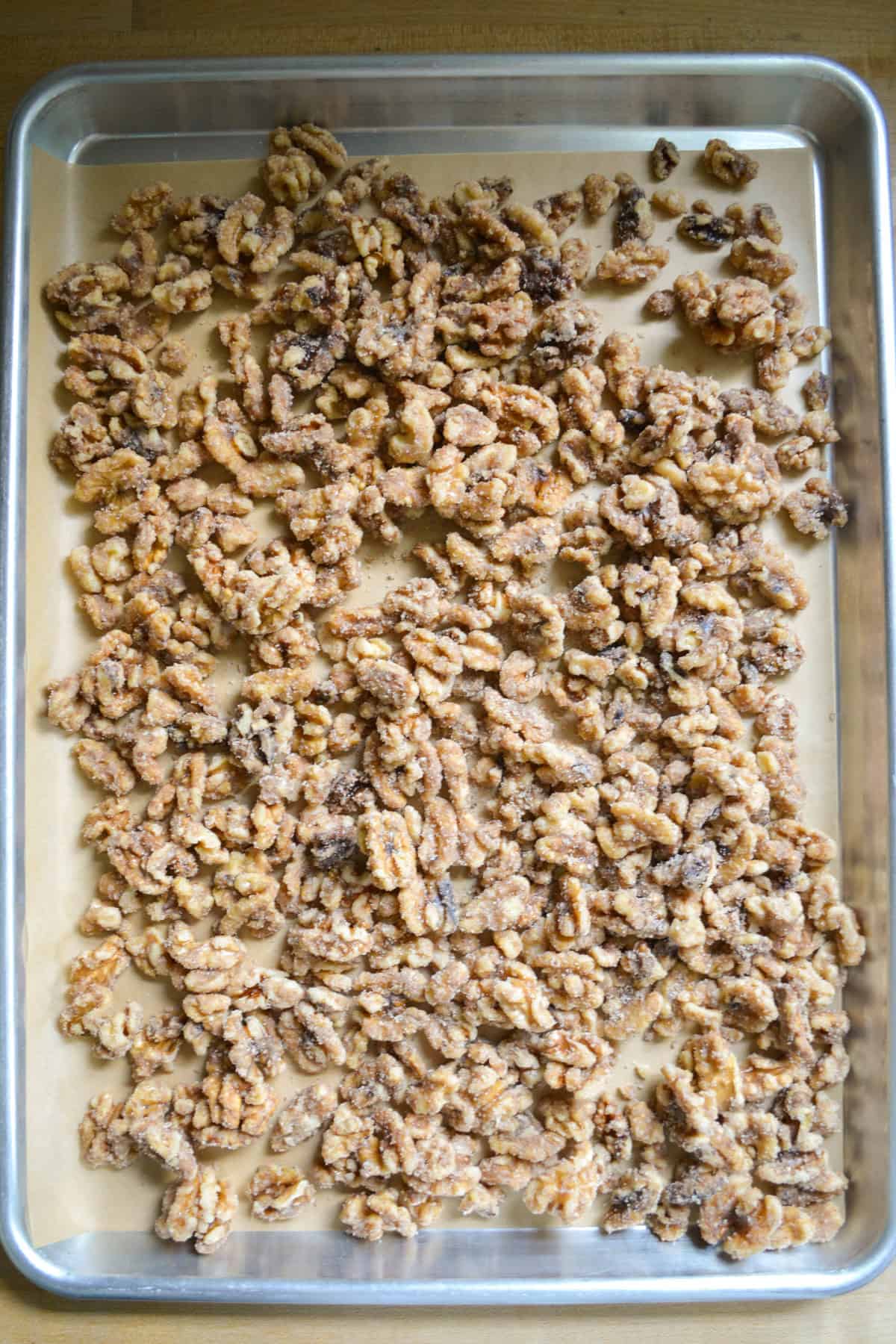 Candied walnuts on a parchment-lined baking sheet.