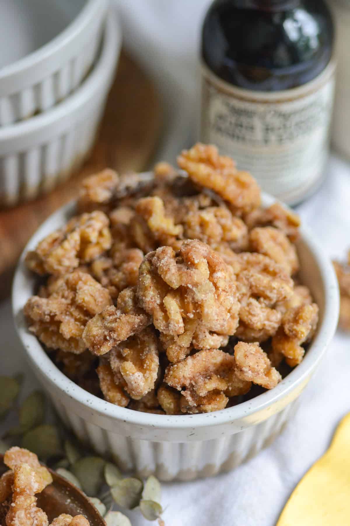 Vegan Candied Walnuts in a small ramekin on a white cloth.