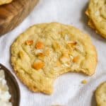 Vegan Coconut Cookie with a bite taken out of it on a white cloth.