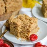 A slice of vegan coffee cake on a small plate with a bite taken out of it.