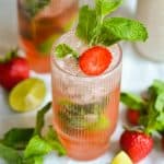 Strawberry Mint Mojito in a glass garnished with a mint sprig and a slice of strawberry.