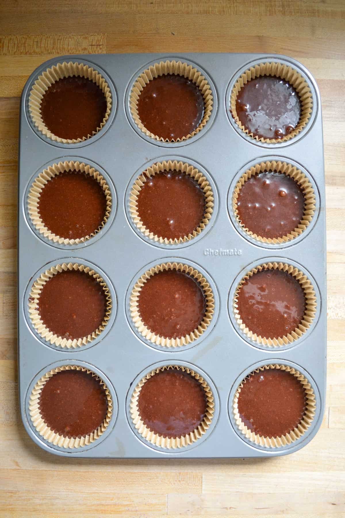 Cupcake batter portioned into a lined cupcake tin.