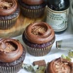 Vegan Chocolate Cupcakes topped with chocolate frosting on a white cloth.