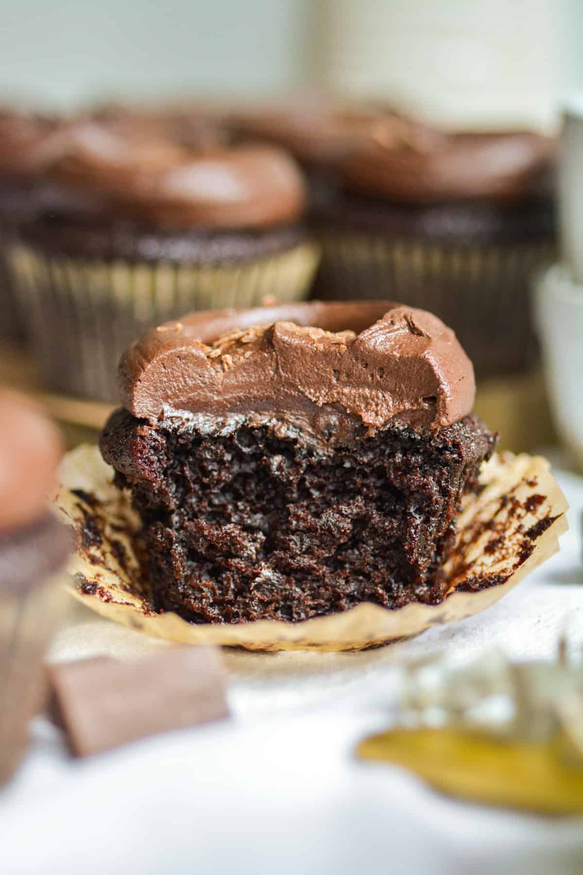 A bite taken out of a vegan chocolate cupcake to show the interior.