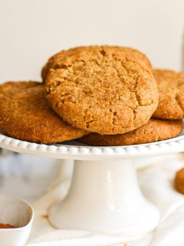 Vegan Chai Cookies stacked on a white cake stand.