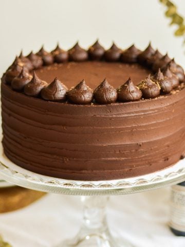 Vegan Chocolate Cake on a glass cake stand.