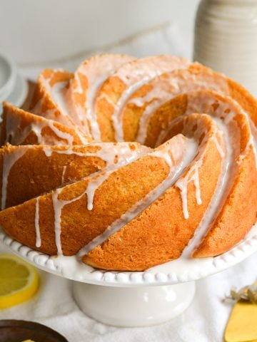 Vegan Lemon Bundt Cake with lemon glaze on a cake stand.