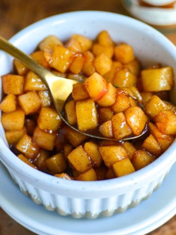 Easy Caramelized Apples in a small ramekin with a gold spoon scooping some apple chunks up.