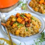 Farrotto with Butternut Squash on a plate with a gold form to the left.