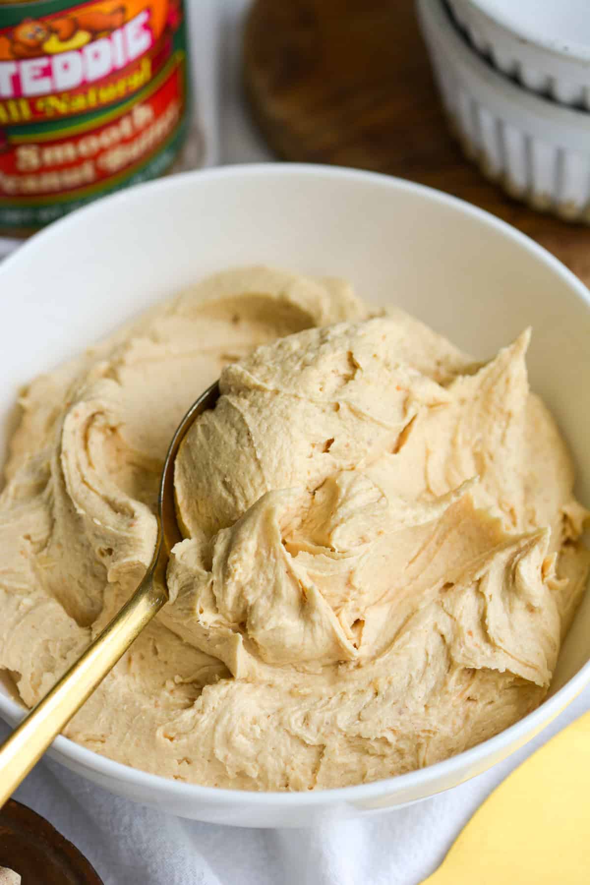 Vegan Peanut Butter Frosting in a bowl with a gold spoon in it.