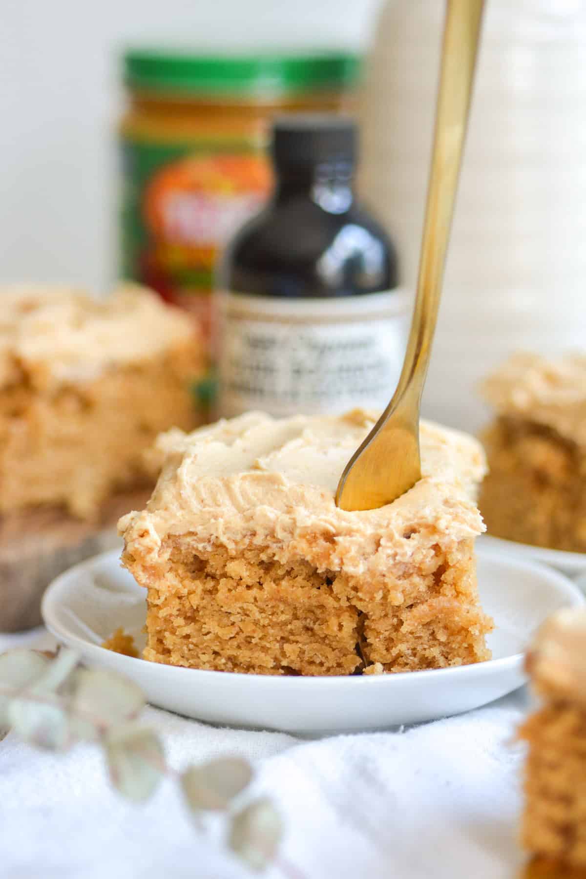 A piece of vegan peanut butter cake with a gold fork in it.