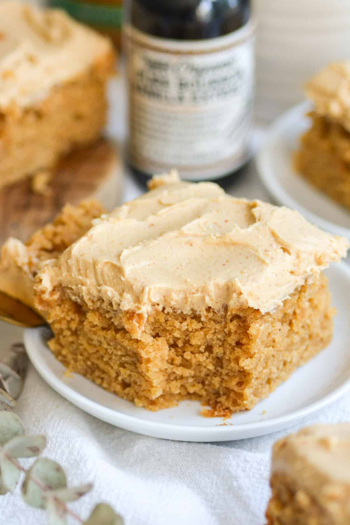 A piece of Vegan Peanut Butter Cake on a small plate with a bite taken out of it.