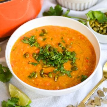 Carrot Red Lentil Soup in a bowl topped with cilantro.