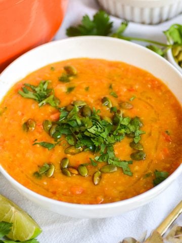 Carrot Red Lentil Soup in a bowl topped with cilantro.