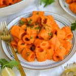 Creamy Harissa Pasta on a plate with a gold fork.