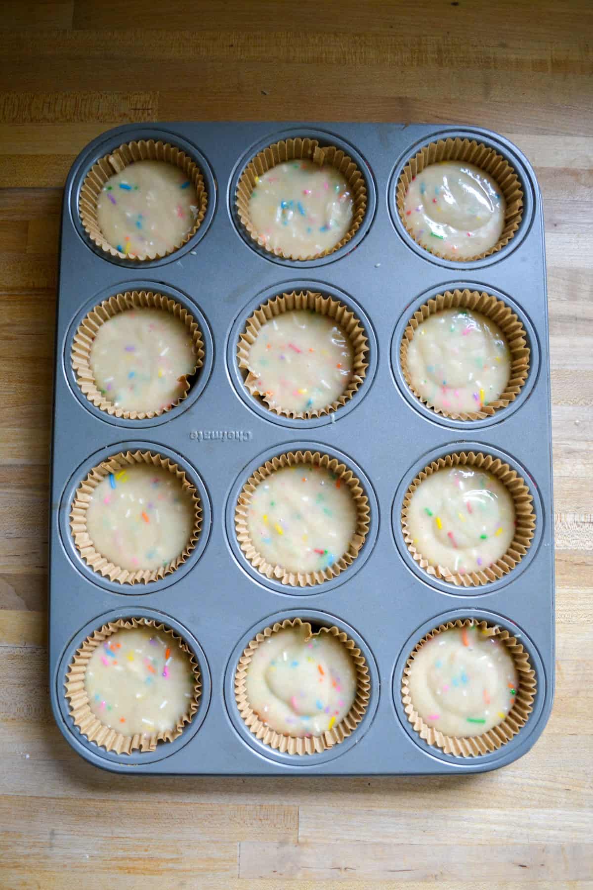 Cupcake batter in a lined cupcake tin.