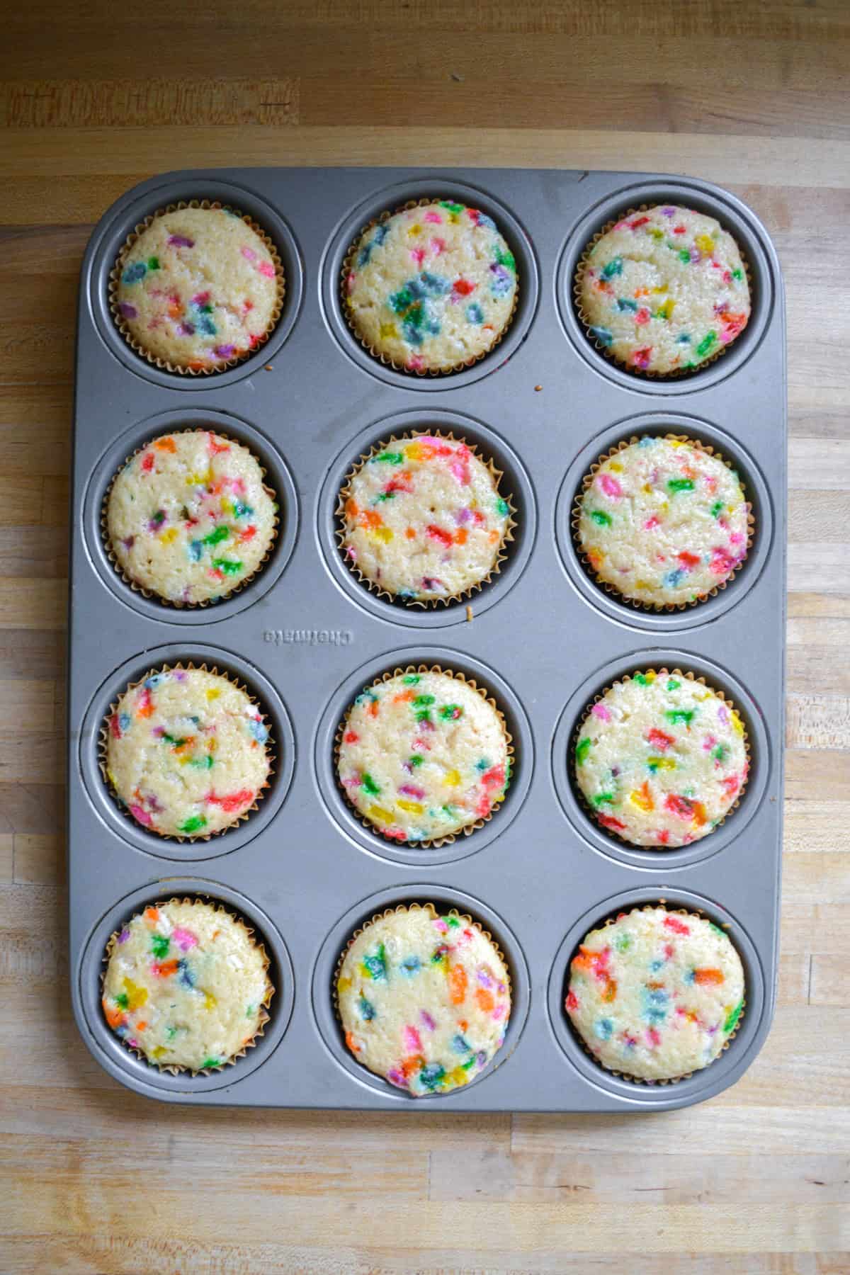 Baked homemade Vegan Funfetti Cupcakes in a cupcake tin.