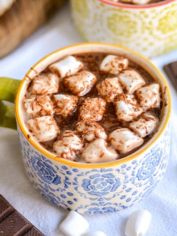 Vegan Oat Milk Hot Chocolate in a mug topped with marshmallows and shaved chocolate.