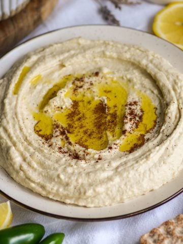 Butter Bean Hummus on a plate topped with olive oil and sumac.