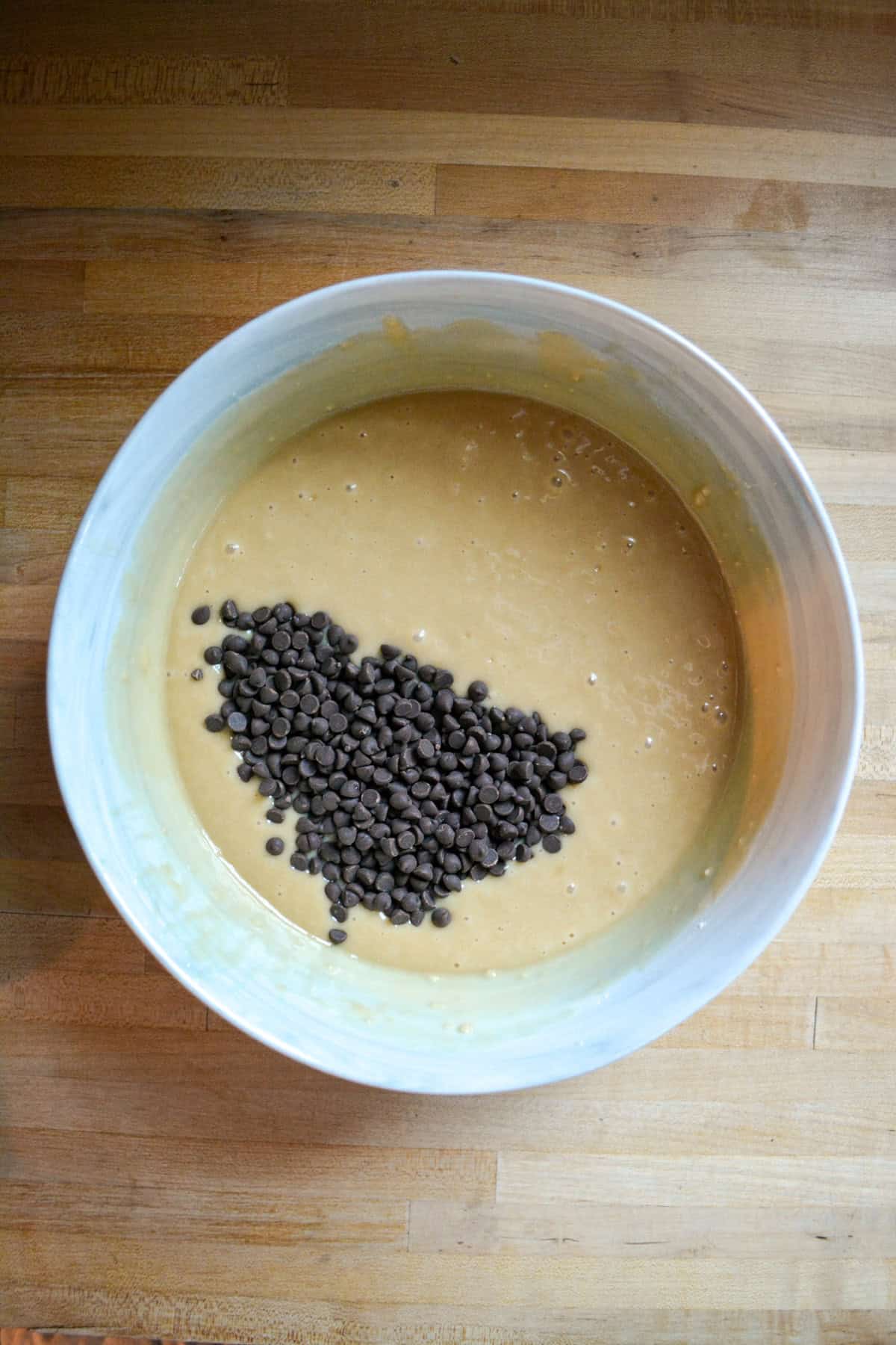 Cake batter with chocolate chips on top in a large mixing bowl.