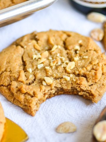 Gluten-Free Vegan Peanut Butter Cookie with a bite taken out of it on a linen cloth.