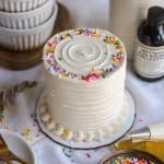 Small Vanilla Cake with sprinkles on top on a linen cloth.