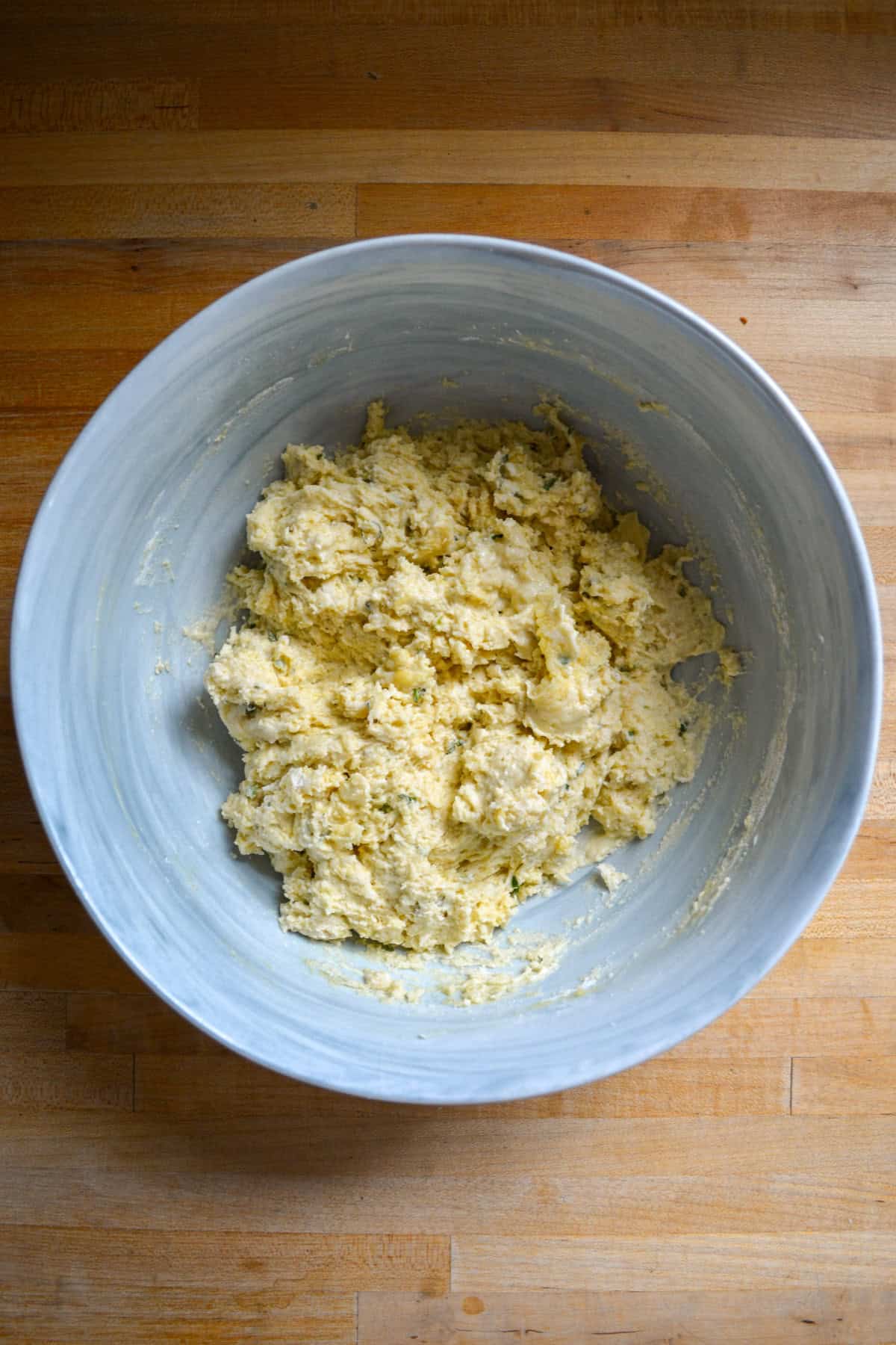 Olive oil and herb biscuit dough in a large mixing bowl.