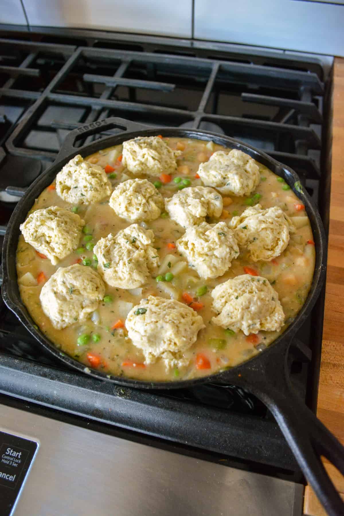 Pot pie filling topped with dollops of herb biscuit topping.