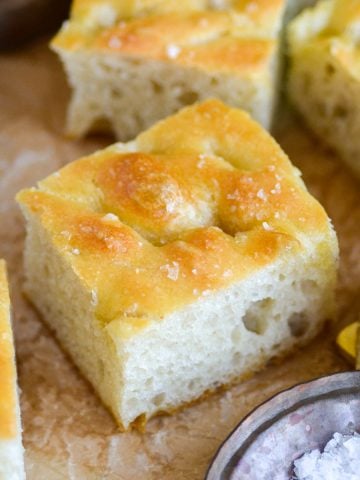 A piece of easy vegan focaccia on a piece of parchment paper.