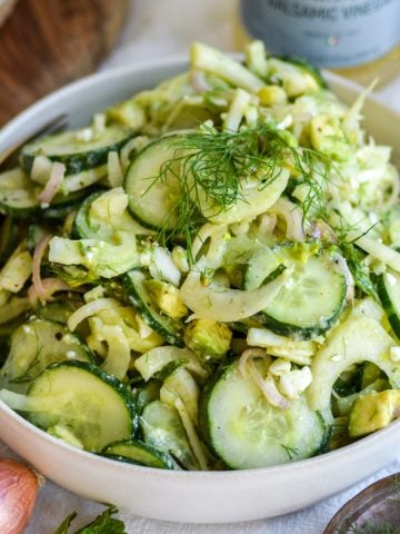 Fennel Cucumber Salad in a shallow bowl with a fork in the bowl.