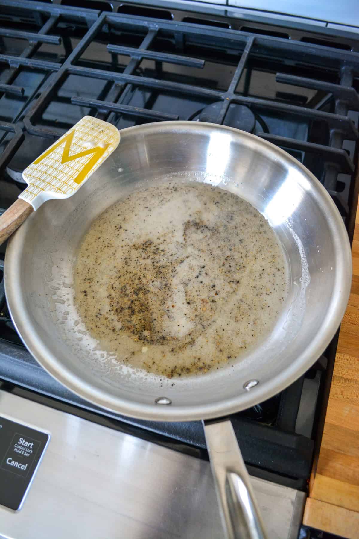 Melted butter and black pepper in a skillet.