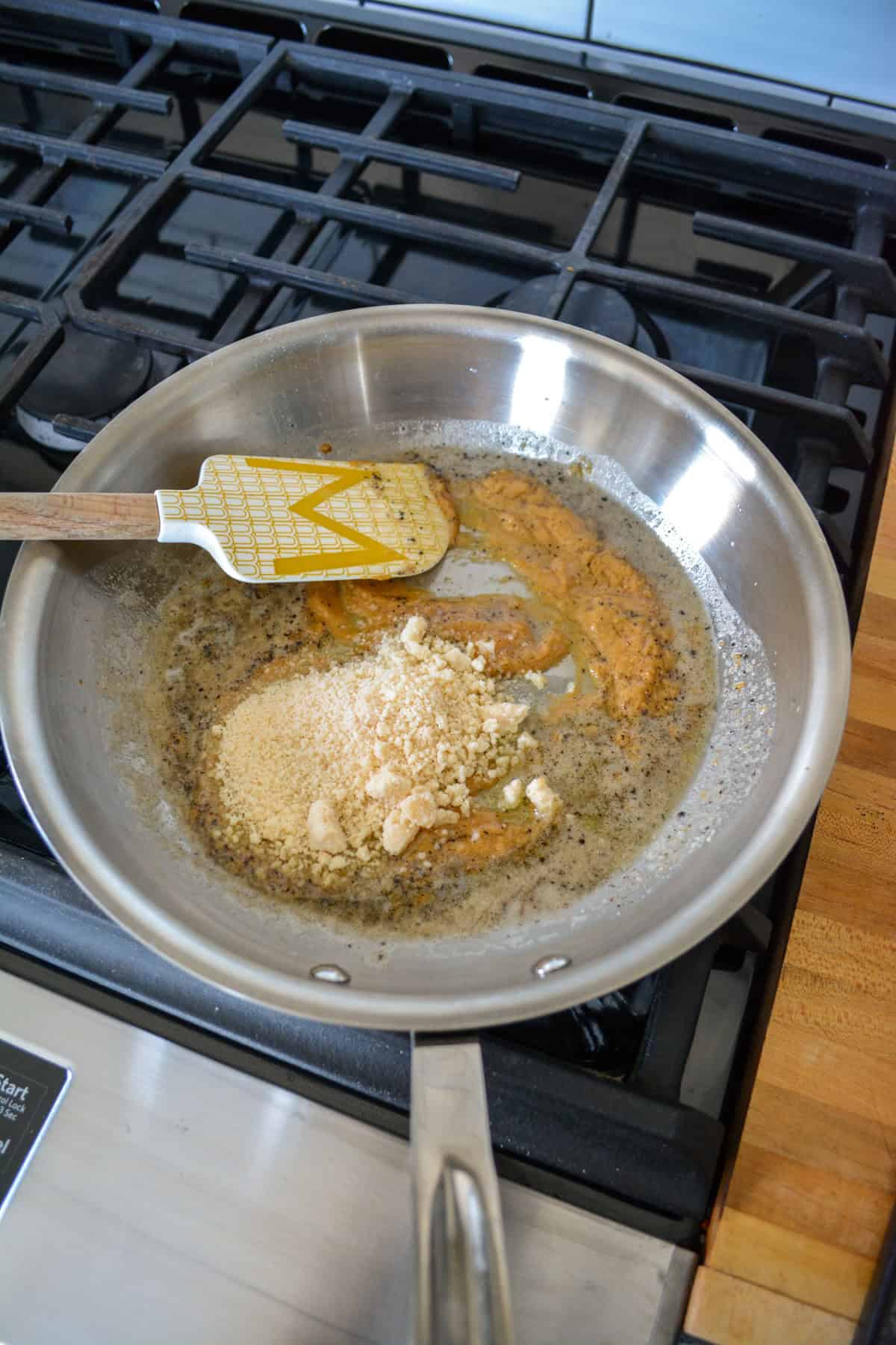 Miso paste and parmesan cheese added to the skillet with the butter and pepper.