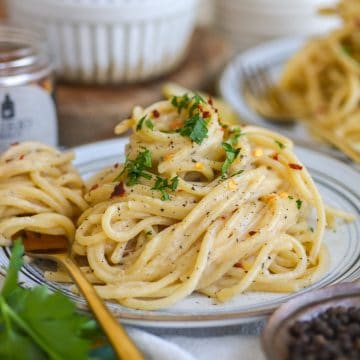 A plate of Vegan Creamy Miso Pasta with a forkful of pasta on the plate.