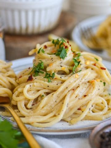 A plate of Vegan Creamy Miso Pasta with a forkful of pasta on the plate.