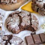 Vegan Gluten-Free Chocolate Crinkle Cookie with a bite taken out of it on a linen cloth.