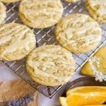 Orange Cardamom Cookies drizzled with orange glaze on a wire cooling rack.
